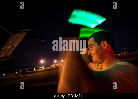 Senior Airman Joseph Goodman, 437th porta antenna squadrone terminale passeggeri tecnico, esegue il marshalling di un Humvee fuori un C-17 Globemaster Foto Stock