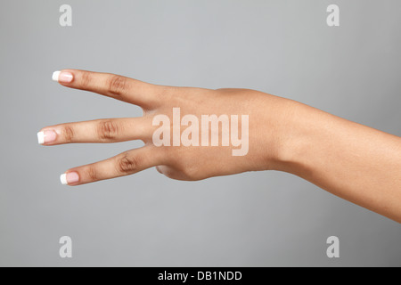 Donna di conteggio a mano tre Foto Stock