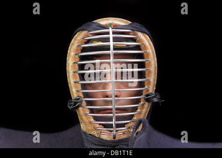 Uomo di kendo con casco su sfondo nero Foto Stock