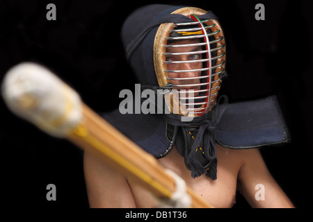 Uomo di kendo con casco su sfondo nero Foto Stock