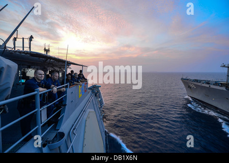 Velisti assegnati alle visite-missili cruiser USS Monterey (CG 61) osservare un rifornimento in mare con i militari Sealift Co Foto Stock