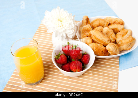 La colazione succo di frutta, croissant e bacche su un tavolo Foto Stock