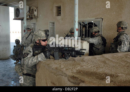 Un American-Iraqi pattugliamento comune cerca la gara-corso per armi nascoste all'ippodromo a Bagdad, Iraq, marzo 2007. I soldati USA appartengono a 'apache' 6° Divisione. Azienda primo battaglione di fanteria 23, il soldato iracheno (L) appartiene al 6° Divisione. Foto: Carl Schulze Foto Stock