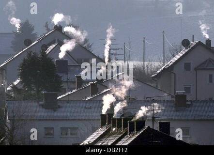 Il fumo aumenta da camini di case in una fredda e frizzante giornata invernale e in Nidderau, Germania, 21 dicembre 2004. Foto: Frank Rumpenhorst Foto Stock