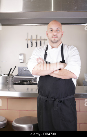 Lo Chef maschio in piedi accanto al fornello in cucina Foto Stock