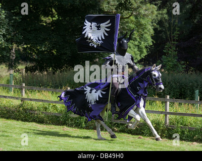 Un cavaliere di entrare nel campo durante un medievale rievocazione evento al Castle Fraser, Scozia Foto Stock