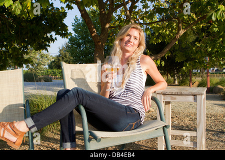 Venti-qualcosa di donna in una vigna al tramonto. Foto Stock