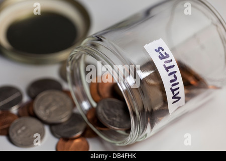 Eventuali fuoriuscite di vasetto in vetro di monete salvate per utilities - USA Foto Stock