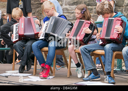 Quattro giovani membri di mantenere la calma e Ceilidh su bambini al Rothbury Festival di musica tradizionale, nell'Inghilterra del Nord, Regno Unito Foto Stock