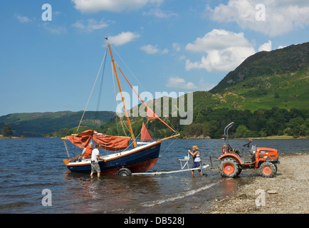 Tre persone alaggio barca a vela sul rimorchio, Glenridding Sailing Club, Ullswater, Lake District, Cumbria, England Regno Unito Foto Stock