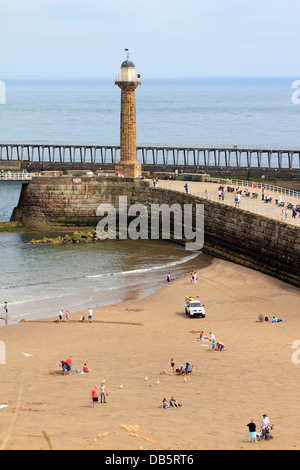 Per i turisti e un bagnino veicolo sulla West Cliff beach dal porto e vecchio faro, Whitby, North Yorkshire, Inghilterra, Regno Unito. Foto Stock