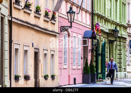 Un business uomo cammina lungo Hastalska street nel Josefov o quartiere ebraico della città vecchia di Praga. Foto Stock