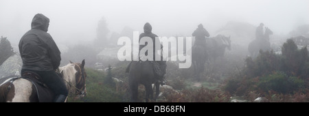 La gente a cavallo nella foresta di nebbia Foto Stock