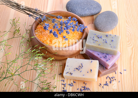 Mazzetto di freschi fiori di lavanda, saponi naturali e di sale da bagno in legno ciotola sul listone sfondo tabella Foto Stock