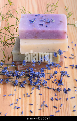 Saponi a base di erbe e fiori di lavanda su un sfondo di legno Foto Stock