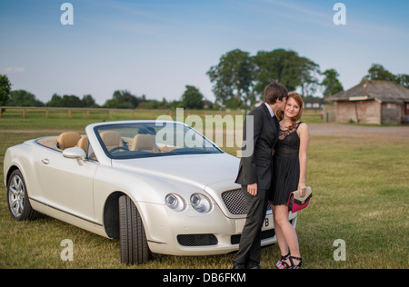 PROM notte bacio di fronte alla lussuosa auto convertibile Bentley Foto Stock