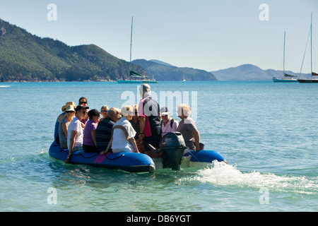 I turisti facendo una gita in barca a ritornare al loro yacht mentre si visita le Isole Whitsunday. Whitsundays, Queensland, Australia Foto Stock