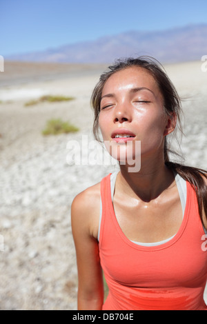 Sete - disidratato donna assetata sudorazione nella Valle della Morte del deserto, STATI UNITI D'AMERICA. La donna che soffre di disidratazione e stanchezza. Foto Stock