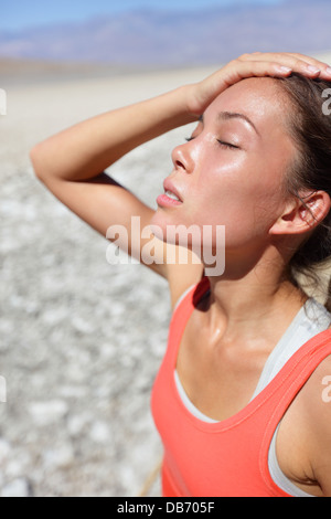 La disidratazione sete concetto donna nella Valle della Morte deserto. Ragazza stanchi e disidratati vicino al colpo di calore dovuti ad alta temperatura e di mancanza di acqua. Foto Stock