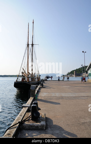 Yacht a vela e i turisti in Oban pier, Argyll and Bute, Scotland, Regno Unito, Europa Foto Stock