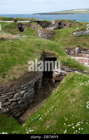 Skara Brae villaggio neolitico sulla terraferma Orkney con la baia di Skaill in background. Foto Stock