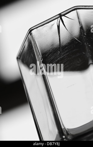 Scheggiato bordo rotto di bere un bicchiere di vetro che mostra tre tri linee di stress in vetro fratturato rim Foto Stock