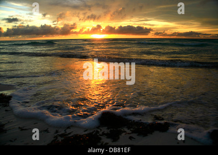Paesi stranieri - Seychelles - Aldabra tramonto tramonto oltre oceano Indiano blue skies nuvole bianche onde schiumose paradiso del surf Foto Stock
