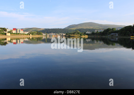 Mooragh Park, Ramsey, Isola di Man, Regno Unito: cielo blu e verdi colline si riflette in un tranquillo lago. Foto Stock