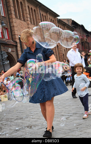 Artisti facendo grandi bolle di sapone durante "Industriada' 2013 street performance a Nikiszowiec piazza principale. Katowice in Polonia. Foto Stock