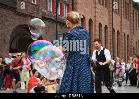 Artisti facendo grandi bolle di sapone durante "Industriada' 2013 street performance a Nikiszowiec piazza principale. Katowice in Polonia. Foto Stock