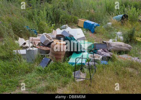 Illegale di discarica di rifiuti in corrispondenza del bordo di un campo Foto Stock