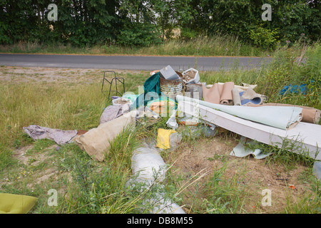 Illegale di discarica di rifiuti in corrispondenza del bordo di un campo Foto Stock