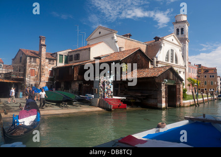 Squero di San Trovaso Gondola cantiere di riparazione con gondola essendo spinto nel canal Dorsoduro Venezia Veneto Italia Foto Stock