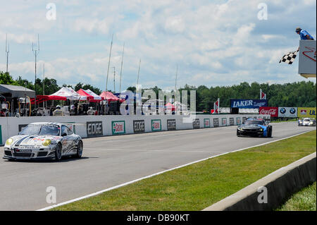 BOWMANVILLE, può., 21 lug 2013 - Il GTC vincitore, n. 22 guidato dal team di Cooper MacNeil e Jeroen Bleekemolen croce sotto la bandiera a scacchi la American Le Mans Racing Mobil 1 SportsCar Grand Prix al Canadian Tire Motorsport Park (precedentemente noto come Mosport Raceway) Foto Stock