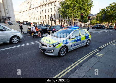 Metropolitan pattuglia di polizia accelerando attraverso strade con luci blu su Londra Inghilterra REGNO UNITO Foto Stock