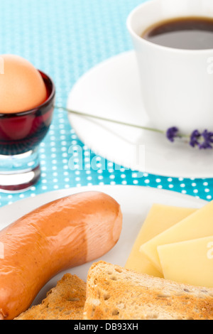 La prima colazione con toast, formaggio, salsiccia, uova e la tazza di caffè. Foto Stock