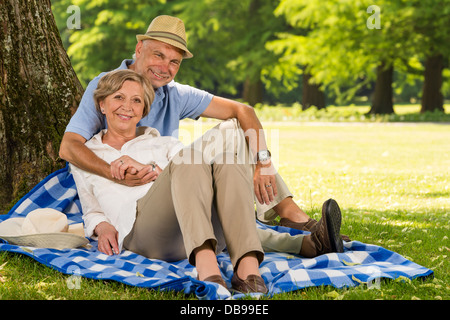 Allegro pensionati avvolgente e rilassante all'esterno soleggiato parco Foto Stock