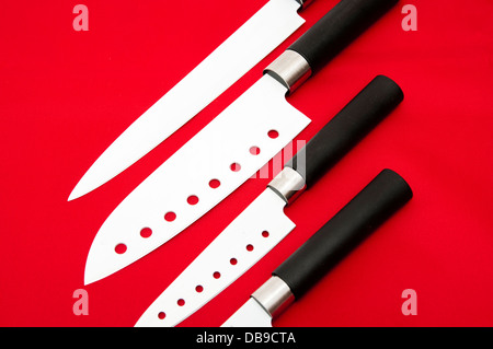 I coltelli di taglio affilati bianco su uno sfondo rosso Foto Stock