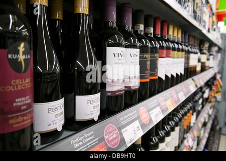 Bottiglie di vino rosso impilati per la vendita su British supermercato Asda di ripiani Foto Stock