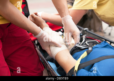 Formazione di primo soccorso paramedico mettendo una benda su un ferito alla mano Foto Stock