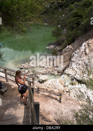 dh Wai o Tapu Thermal Wonderland WAIOTAPU NUOVA ZELANDA Donna Tourist fotografando il paesaggio geotermico Lago Ngakoro cascata piscine scattare foto Foto Stock