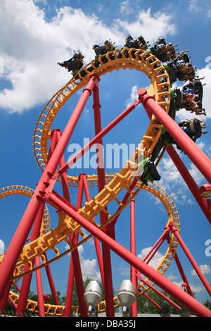 Scary capovolto e divertimento con un colorato Looping Roller Coaster su una bella giornata di sole presso il parco di divertimenti Foto Stock