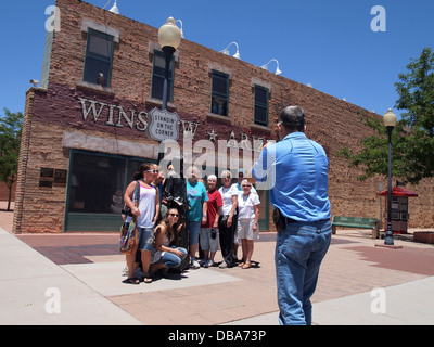 I turisti che posano per una foto con la scultura in bronzo a Standin' all'angolo Park in Winslow, Arizona, Stati Uniti d'America Foto Stock