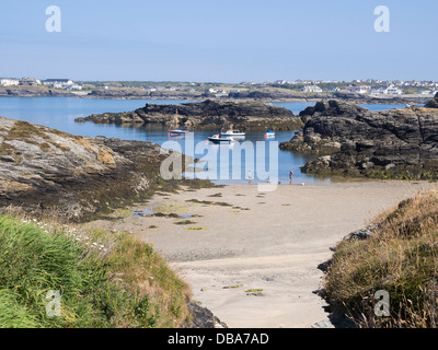 Linea costiera e la costa di scena a bassa marea in estate con barche ormeggiate in Porth Diana, TREARDDUR BAY, Isola Santa, Isola di Anglesey, Galles del Nord, Regno Unito Foto Stock