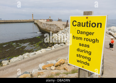 Il simbolo di attenzione circa il mare agitato a Whitby Harbour parete, North Yorkshire. Foto Stock