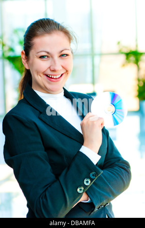 Ragazza in un business suit tenendo la sua mano in compact disc Foto Stock