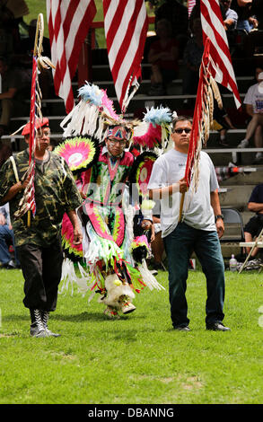 Winnebago, Nebraska, Stati Uniti d'America. 26 Luglio, 2013. CRAIG CLEVELAND JR. centro, membro dell'Ho-Chunk Winnebago Tribe, Winnebago, NE, danze dietro ELWOOD HARDEN, sinistra e HAROLD CLEVELAND JR. destra, anche della Ho-Chunk Winnebago Tribe durante la processione delle bandiere durante il 147th homecoming annuale celebrazione, "Pow Wow, della tribù Winnebago del Nebraska. La celebrazione commemora il ritorno della guerra capo piccolo sacerdote e la società "un'Fort Omaha scout, 34th Nebraska volontari. Questa banda di indiani hanno combattuto da 1863-66 con generale A. Sully dell'esercito degli Stati Uniti contro le bande Lakota, Foto Stock