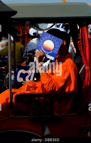 Phnom Penh Cambogia in luglio 26th, 2013. Sam Rainsy fautore di un monaco buddista, nasconde la sua faccia dietro una Cambogia salvataggio nazionale segno di partito. Molti Sam Rainsy sostenitori per nascondere le loro facce nel timore di ritorsioni da Hun Sen e il suo attuale governo. Sam Rainsy è stato in auto-esilio in Francia dal 2009. Egli era stato concesso un regale perdono dal Re di Cambogia e restituito alla Cambogia su luglio 19th, 2013. Credito: Kraig Lieb / Alamy Live News Foto Stock