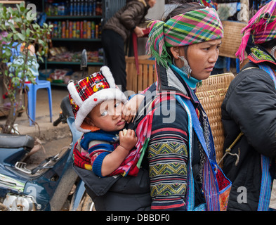 Una donna non identificato e il suo bambino attendere sul mercato il 18 gennaio 2008 in SAPA, Vietnam. Foto Stock