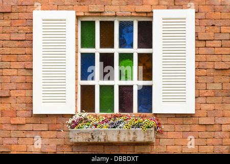 Finestra di vetro colorato sul muro di mattoni Foto Stock